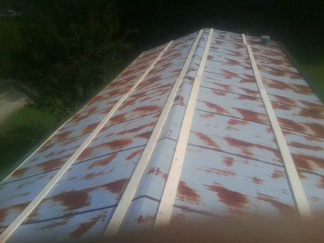 Rusted metal roof panels with new wood purlins before replacement — Storm Damage Roof Repair in Pilot by Roofing Brothers