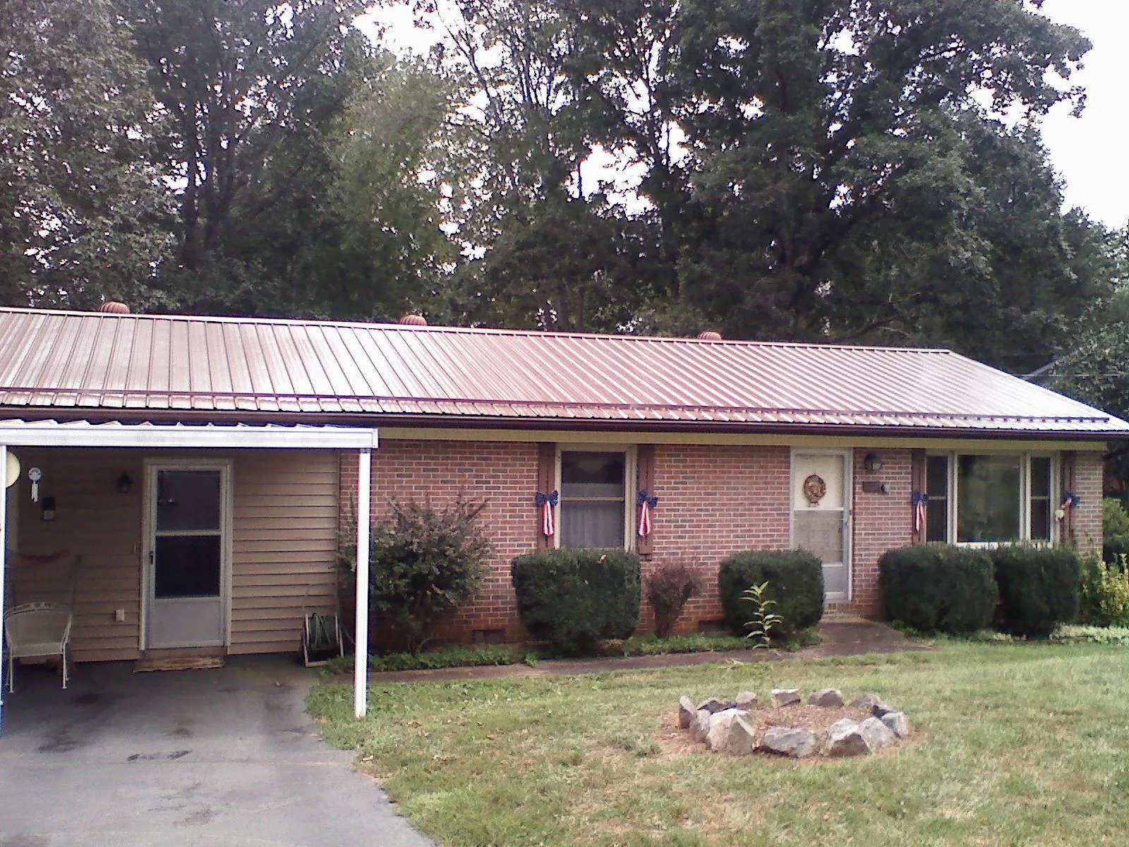 Bronze metal roof and carport on a brick ranch home — Roof Repair work by our crew in Pilot